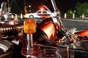 motorcycle lying on side following a crash. Police car is seen in background.